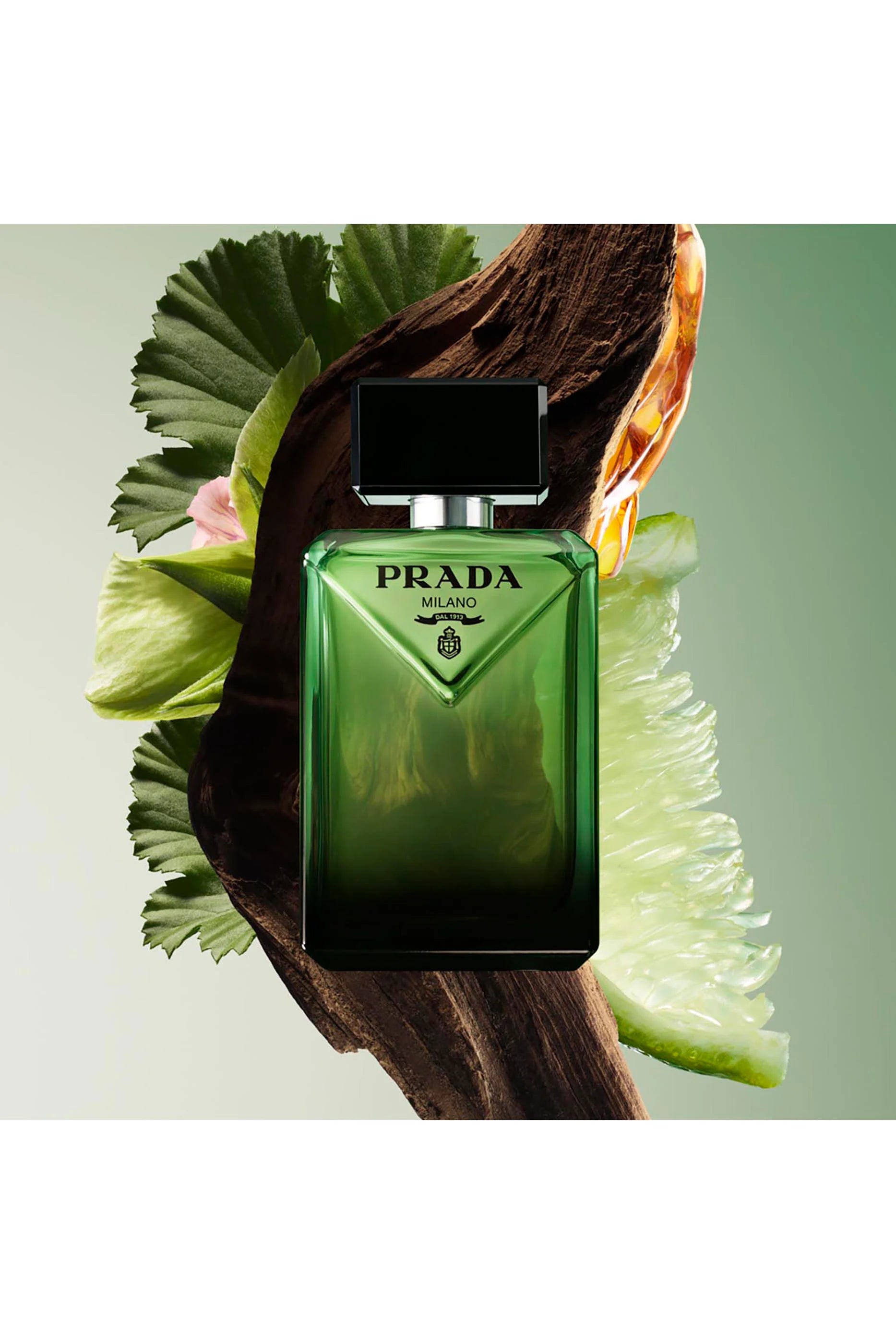 Green Prada perfume bottle with leaves on a light green background