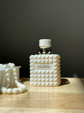 Valentino perfume bottle with textured design on a wooden surface
