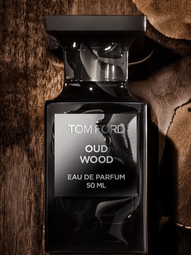 Tom Ford Oud Wood Eau de Parfum bottle on a textured brown background
