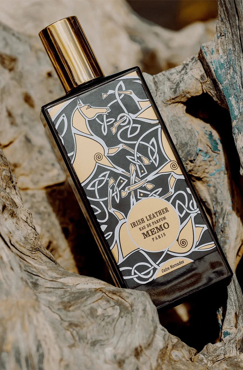 Perfume bottle with decorative label on a textured stone surface