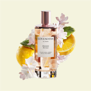 Perfume bottle labeled 'Lovenotes by ariana' with lemons and flowers on a light yellow background