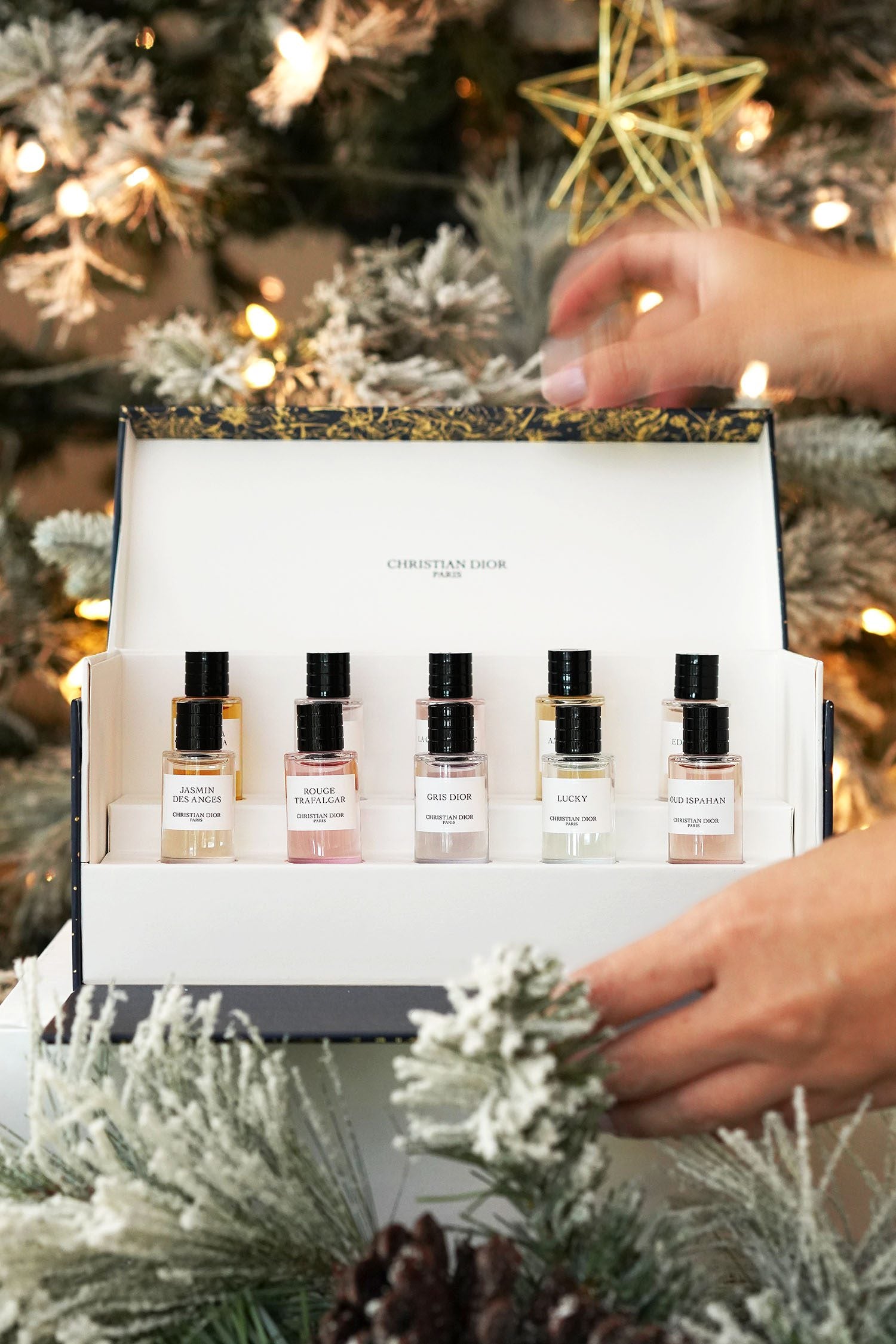 Set of perfume bottles in a gift box with a Christmas tree in the background