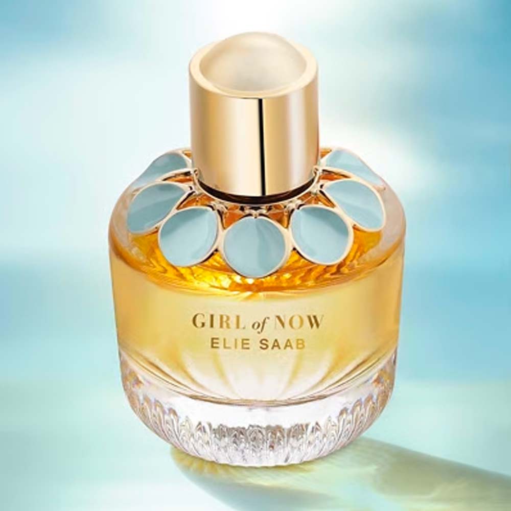 Perfume bottle labeled 'Girl of Now' by Elie Saab on a gradient blue background