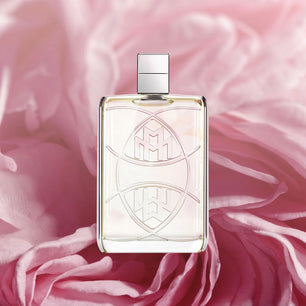 Perfume bottle with decorative design on a pink fabric background
