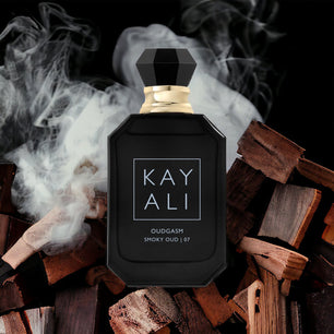 Black perfume bottle labeled 'KAY ALI' on a background of smoky wood.
