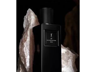 Black perfume bottle with YSL logo against a dark background