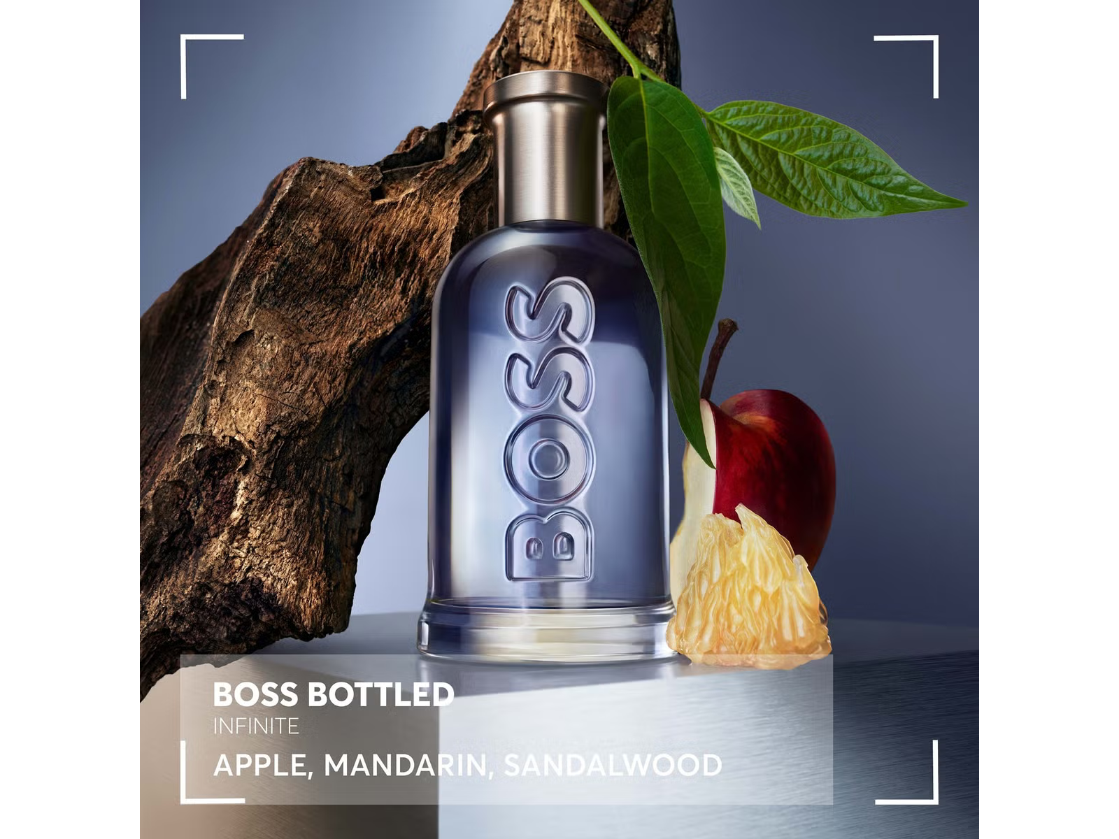 BOSS bottled perfume with an apple and sandalwood on a dark background
