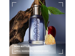 BOSS bottled perfume with an apple and sandalwood on a dark background