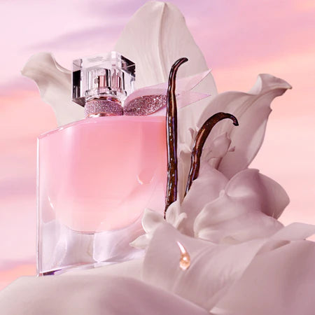 Pink perfume bottle with a decorative cap on a soft pink background