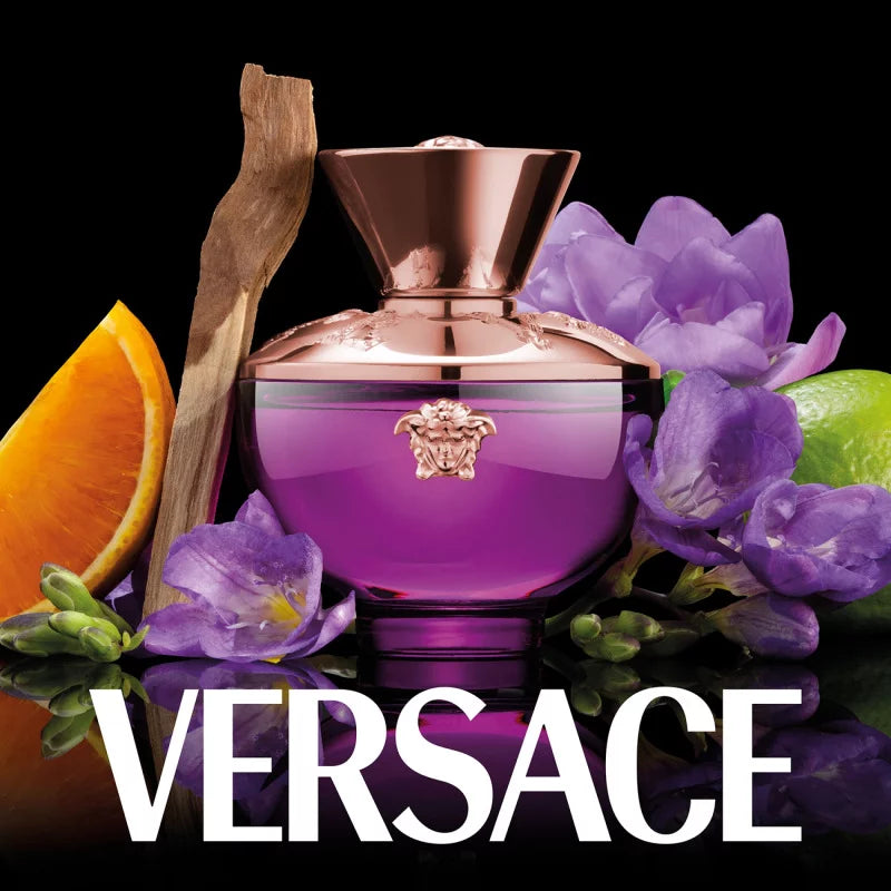 Versace perfume bottle with purple flowers, orange, and lime on a black background